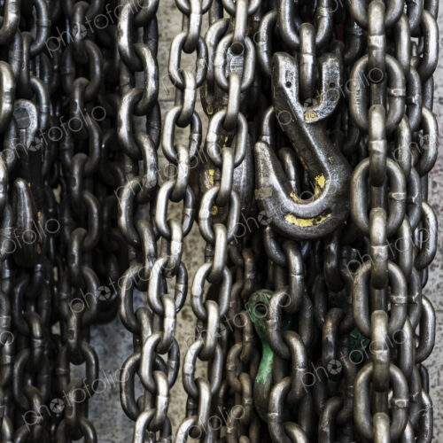 Closeup still life of chains and lift hook used in a sheet metal factory.