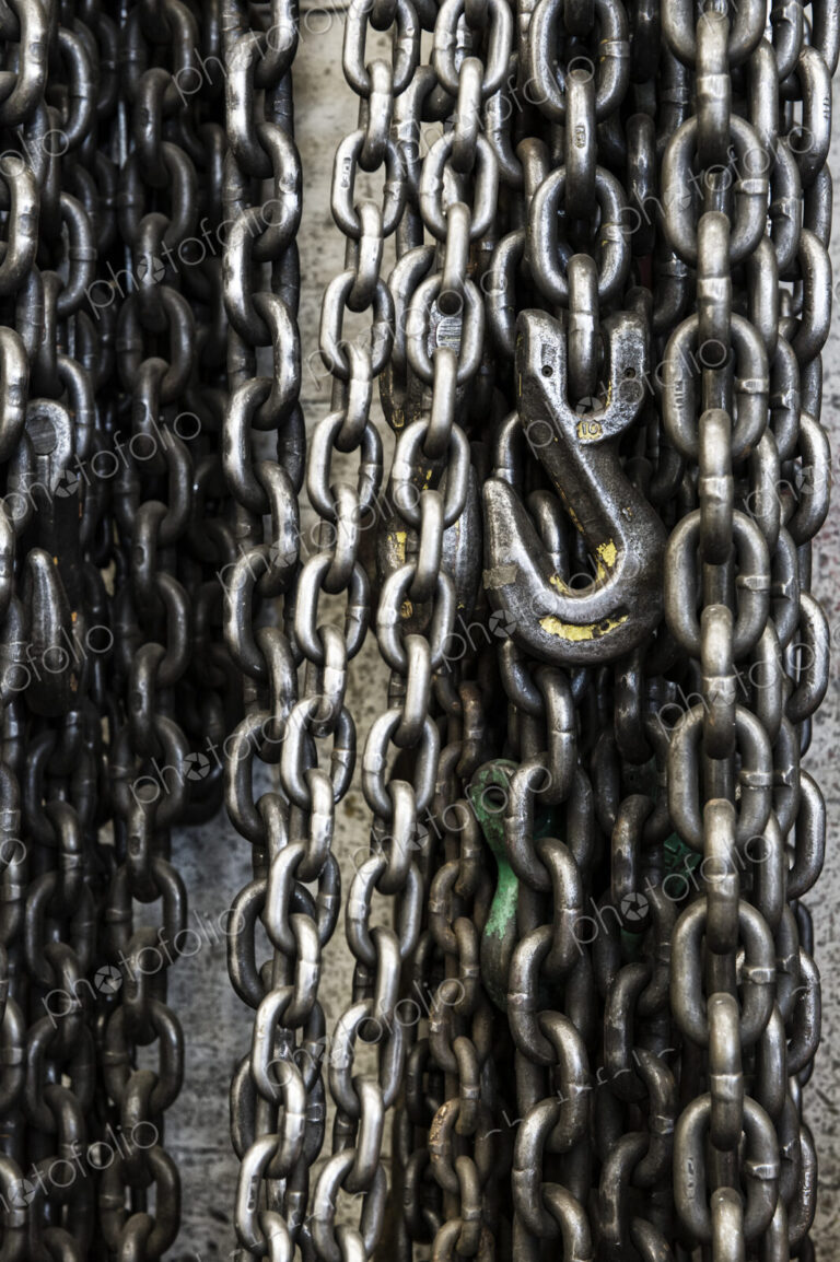 Closeup still life of chains and lift hook used in a sheet metal factory.