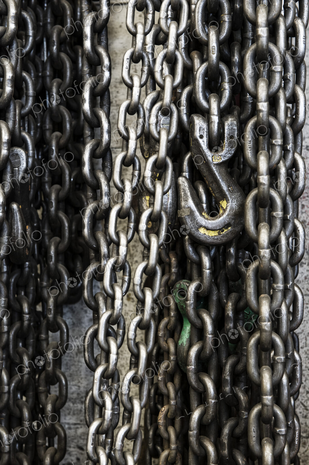 Closeup still life of chains and lift hook used in a sheet metal factory.