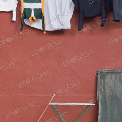 Clothes hanging on laundry line on wall.