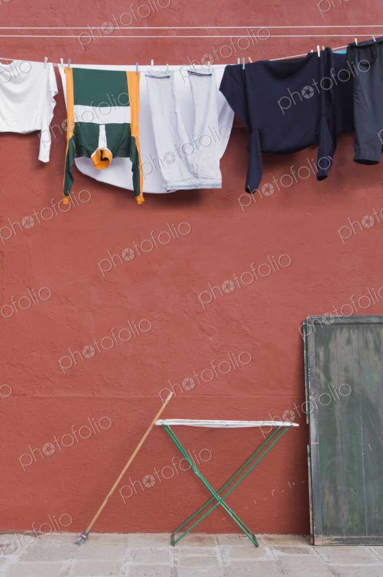 Clothes hanging on laundry line on wall.