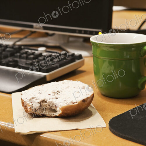 Coffee Cup and Bagel on a Desk Coffee Cup and Bagel on a Desk