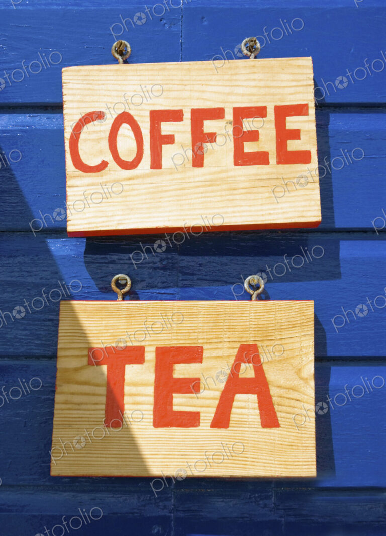 Coffee and tea signs on wooden wall or building exterior.