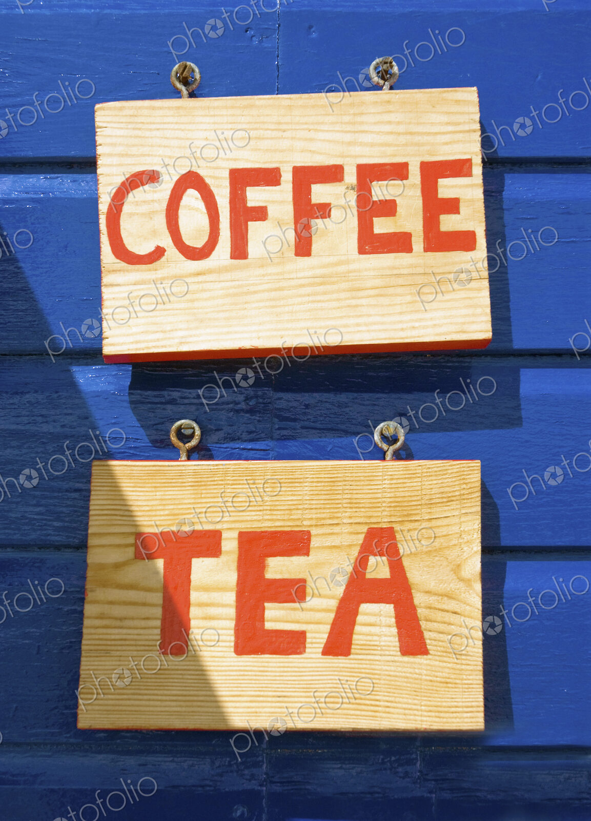 Coffee and tea signs on wooden wall or building exterior.