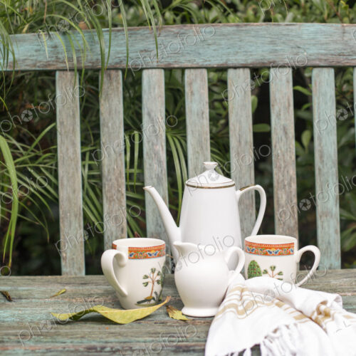 Coffee pot and mugs on a wooden garden bench. Coffee pot and mugs on a wooden garden bench.