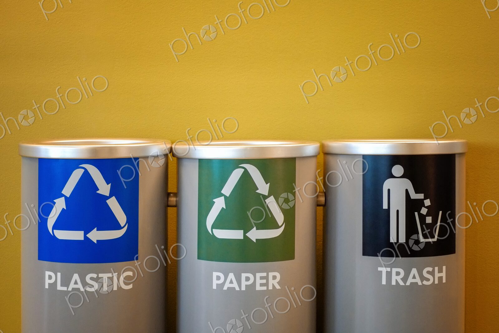 Color-coded bins for plastic recycling, paper recycling, and general trash disposal -…
