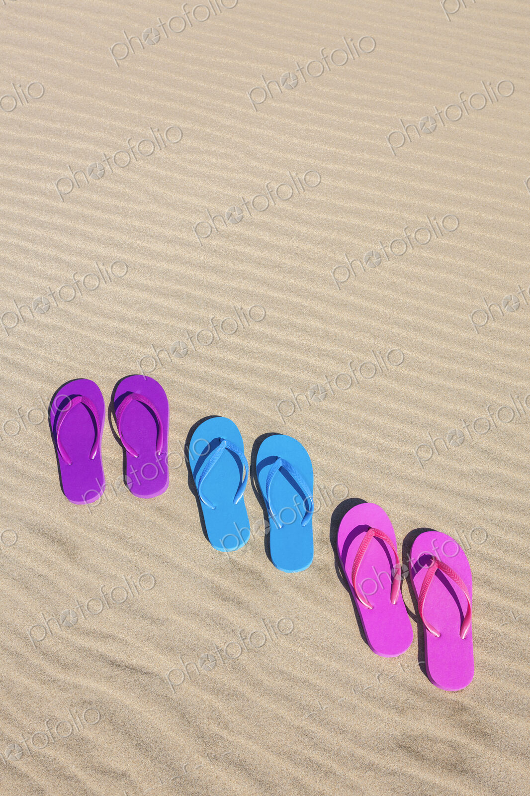 Colorful flip flops on sand