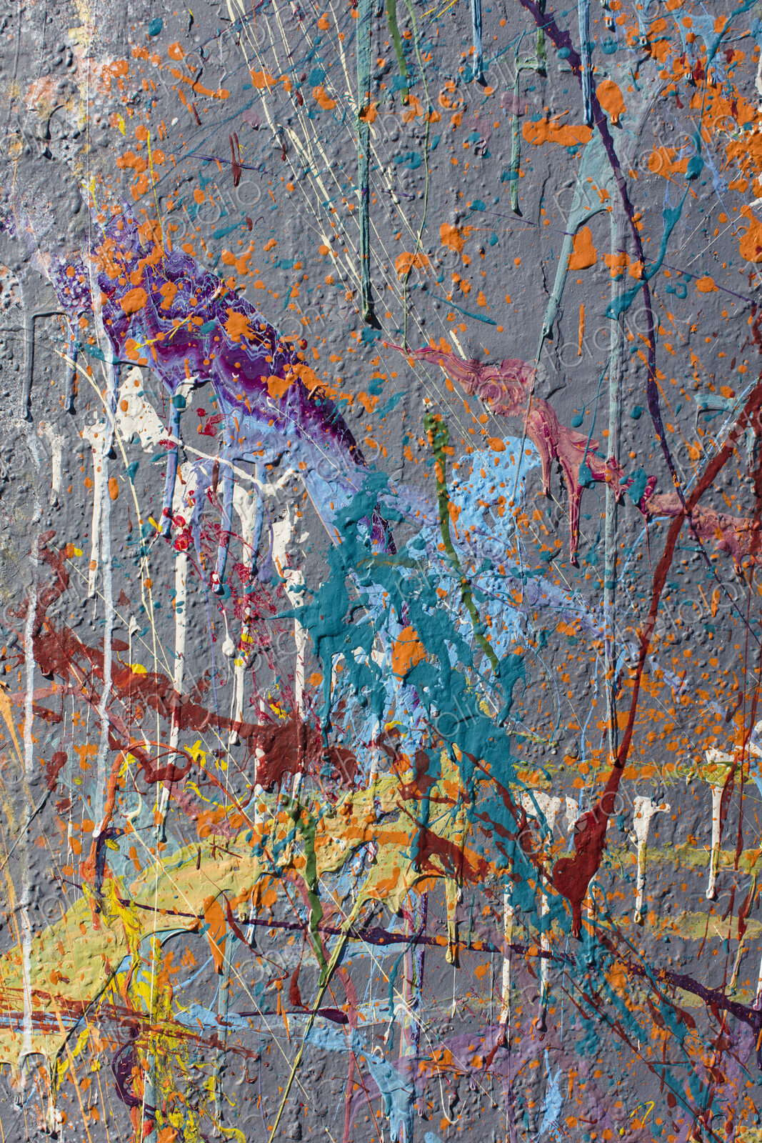 Colorful graffiti paint splattered and dripping on urban wall, close up