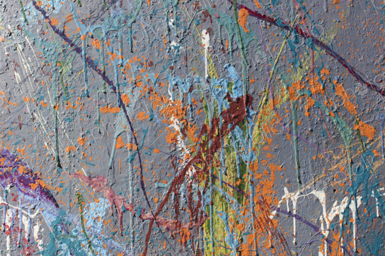 Colorful graffiti paint splattered and dripping on urban wall, close up