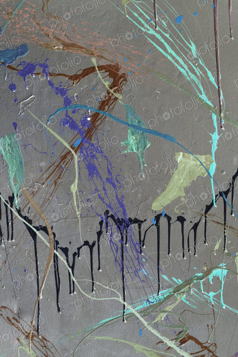 Colorful graffiti paint splattered and dripping on urban wall, close up