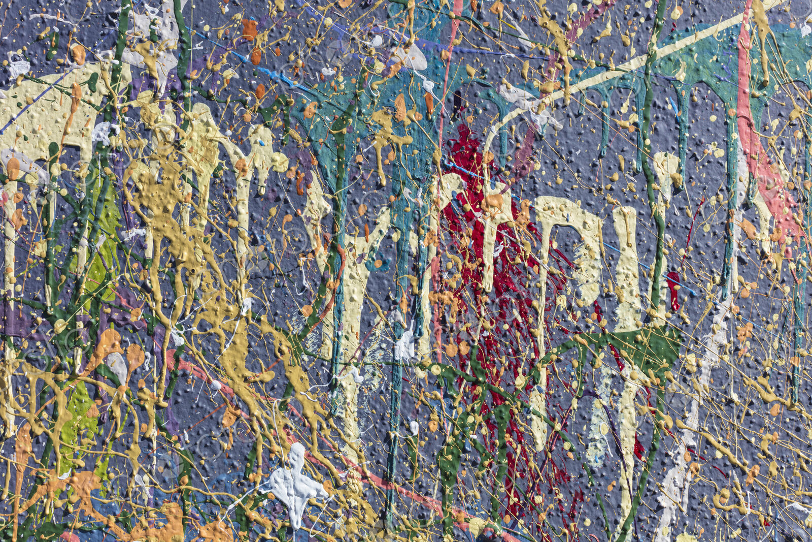 Colorful graffiti paint splattered and dripping on urban wall, close up