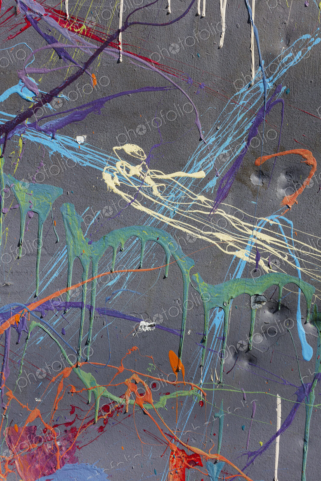 Colorful graffiti paint splattered and dripping on urban wall, close up