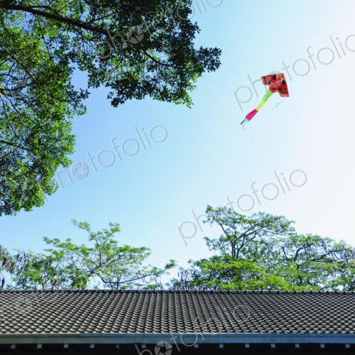 Colorful kite flying over traditional Chinese roof. Colorful kite flying over traditional Chinese roof.