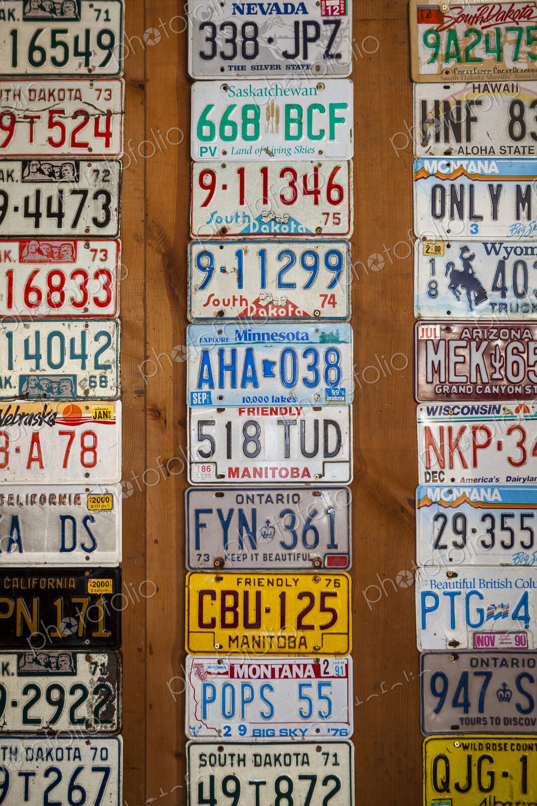 Colorful vintage license plates from the United States and Canada displayed on a…