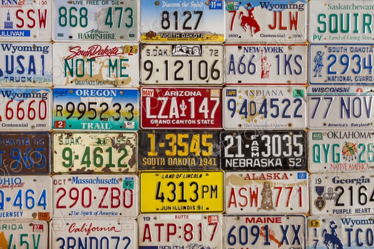 Colorful vintage license plates from the United States and Canada displayed on a…