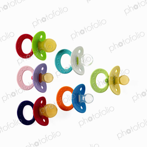 Coloured plastic baby pacifiers, dummies or soothers.