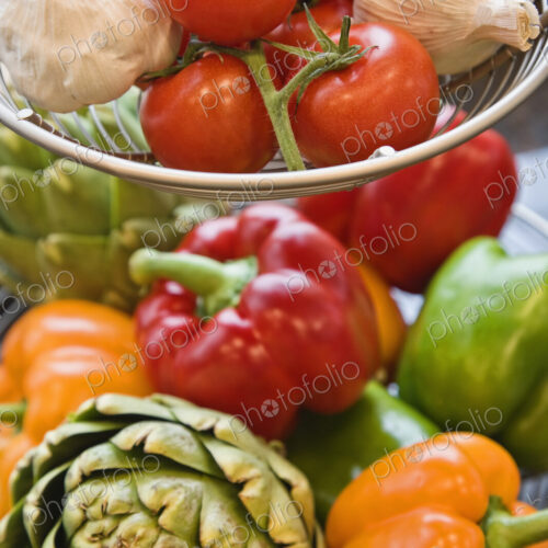 Colourful fresh vegetables on a counter top in a kitchen.