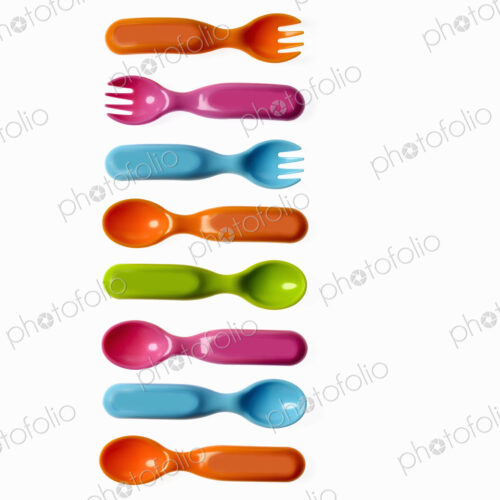 Colourful plastic spoons and forks, for use by infants and babies.