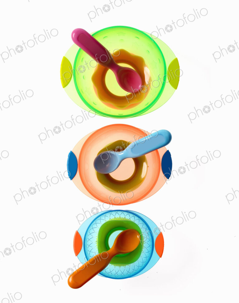 Colourful plastic spoons for use by infants and babies. Coloured plastic bowls.