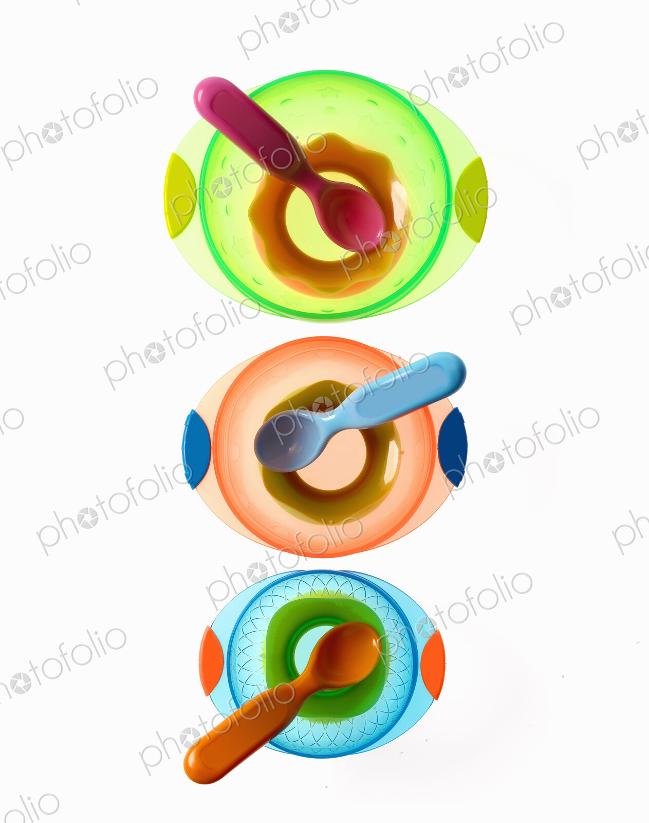 Colourful plastic spoons for use by infants and babies. Coloured plastic bowls.