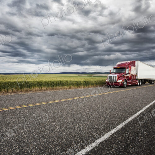 Commercial truck driving though wheat fields of eastern Washington, USA at sunset. Commercial truck driving though wheat fields of eastern Washington, USA at sunset.