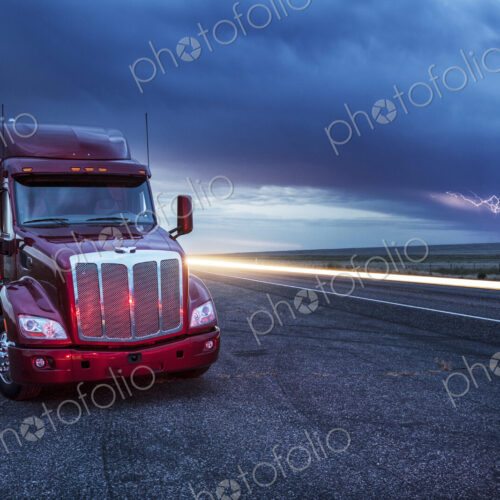 Commercial truck parked on the verge of rural road late in the day, lightning in the… Commercial truck parked on the verge of rural road late in the day, lightning in the…