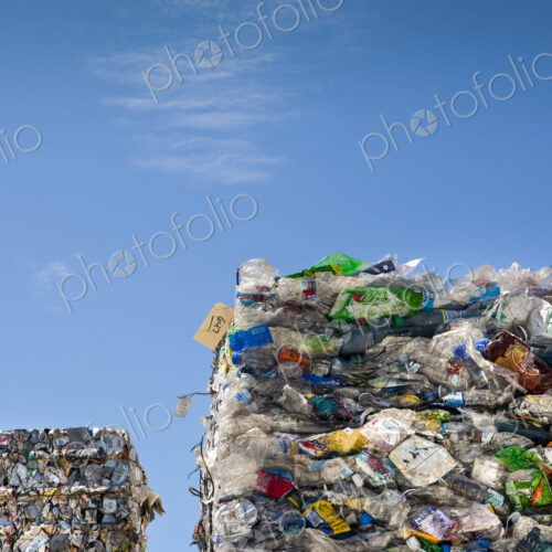 Commercial waste management, bales of recycling materials, plastics stacked up.