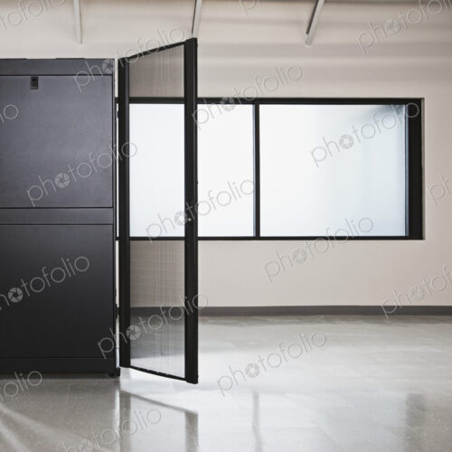 Computer server cabinet with door open and window in office. Computer server cabinet with door open and window in office.