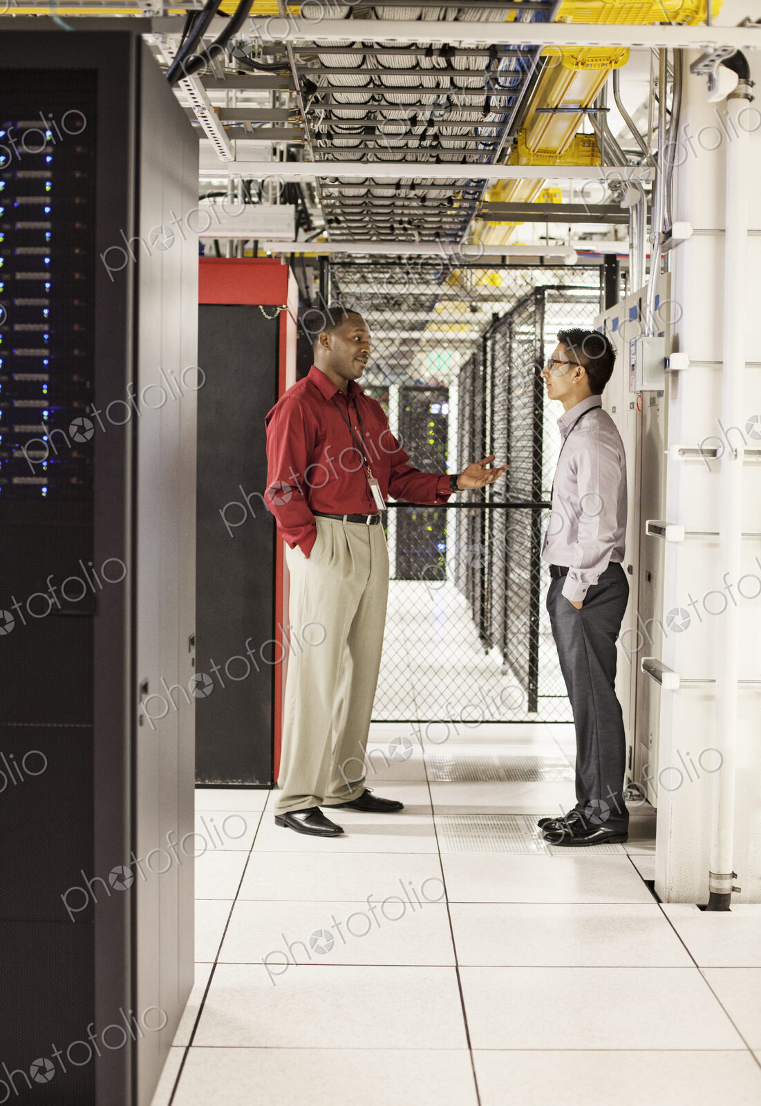 Computer technicians discussion an issue in a large computer server farm.