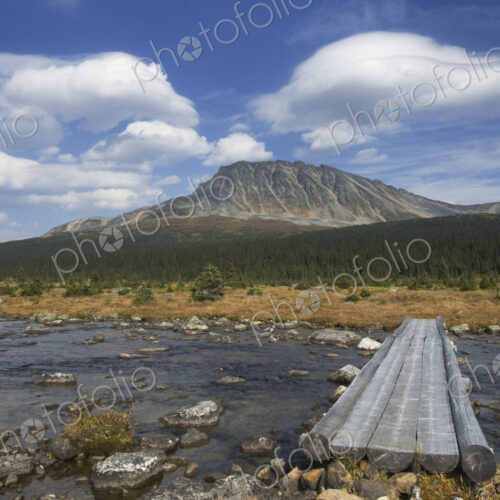 Concrete footbridge over river in remote landscape Concrete footbridge over river in remote landscape