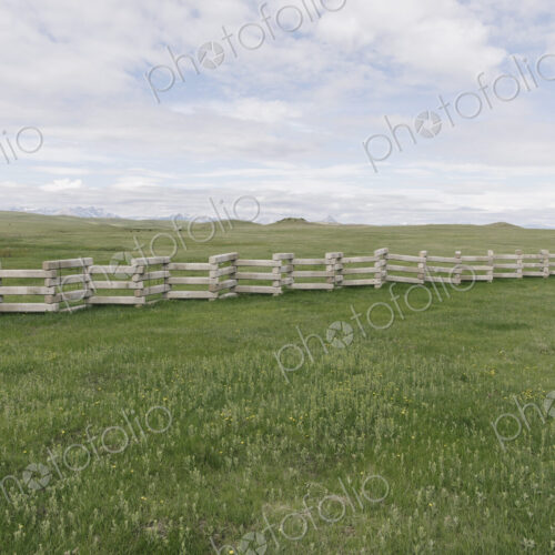 Concrete snow barrier, angled fencing across a verdant mountain meadow. Concrete snow barrier, angled fencing across a verdant mountain meadow.