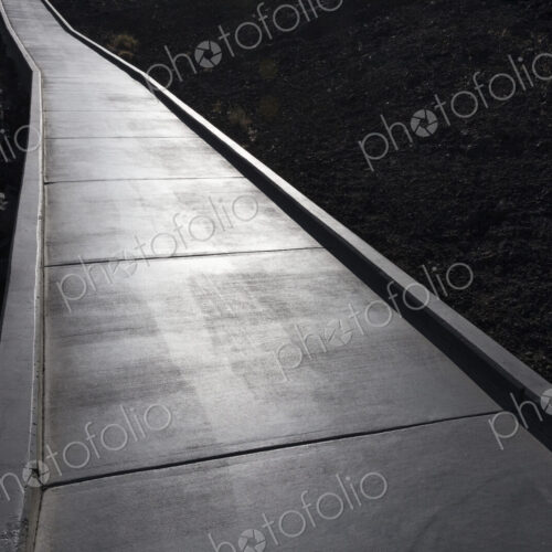 Concrete walkway extends through lava field, Craters of the Moon National Monument. Concrete walkway extends through lava field, Craters of the Moon National Monument.