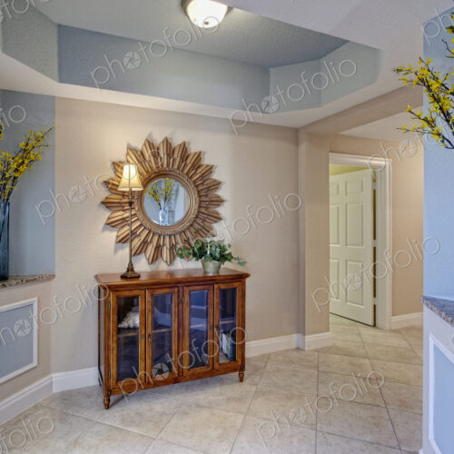Condominium Interior, a hallway with display cabinet and sunburst style mirror, vases… Condominium Interior, a hallway with display cabinet and sunburst style mirror, vases…