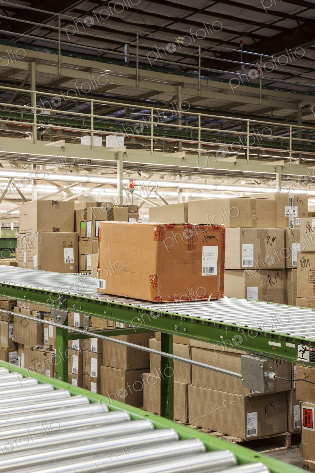 Conveyor belt sytem and cardboard boxes of products in a distribution warehouse.