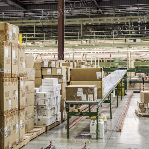 Conveyor belt sytem and cardboard boxes of products in a distribution warehouse.