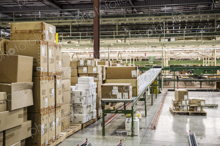 Conveyor belt sytem and cardboard boxes of products in a distribution warehouse.