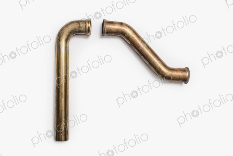 Copper Plumbing Pipe Sections. Two pieces of copper pipe. Shiny formed shaped pieces.