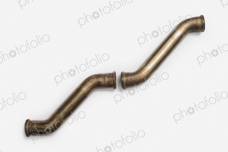 Copper Plumbing Pipe Sections. Two pieces of copper pipe. Shiny formed shaped pieces.