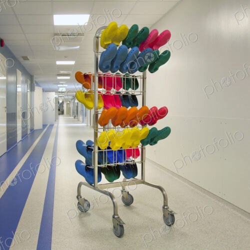 Corridor and waiting areas of a modern hospital, a rack with colourful surgical clogs. Corridor and waiting areas of a modern hospital, a rack with colourful surgical clogs.