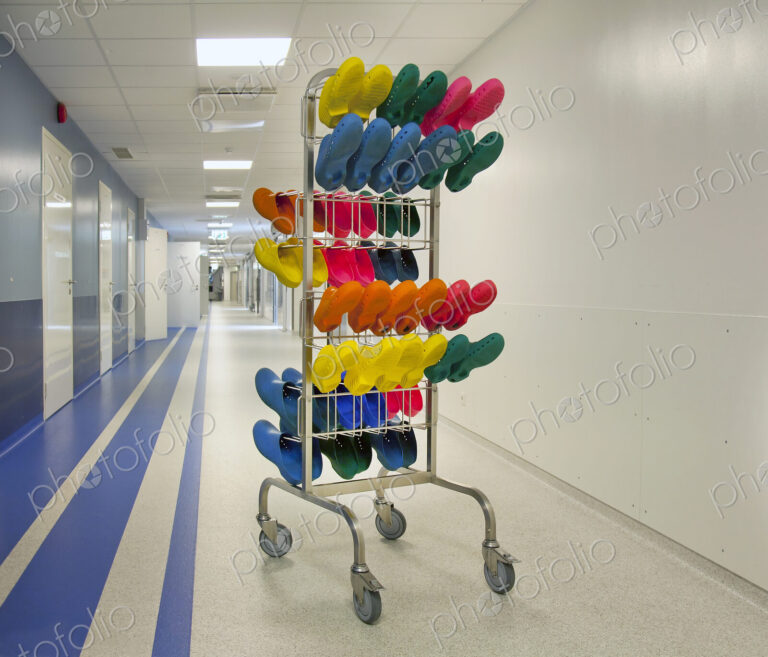 Corridor and waiting areas of a modern hospital, a rack with colourful surgical clogs.