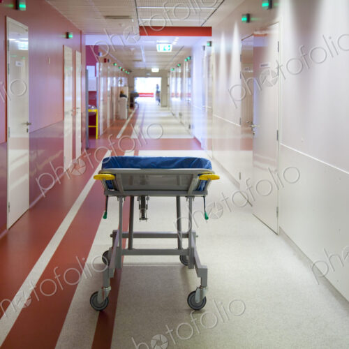 Corridor and waiting areas of a modern hospital with seating, a trolley bed wih blue… Corridor and waiting areas of a modern hospital with seating, a trolley bed wih blue…