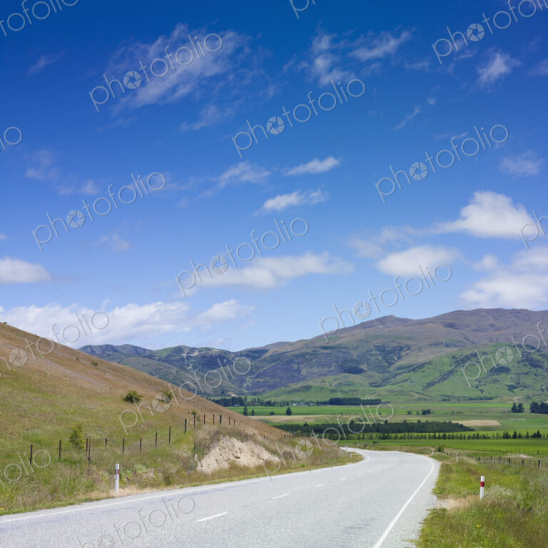 Country road in the South Island of New Zealand, a valley and mountain range.