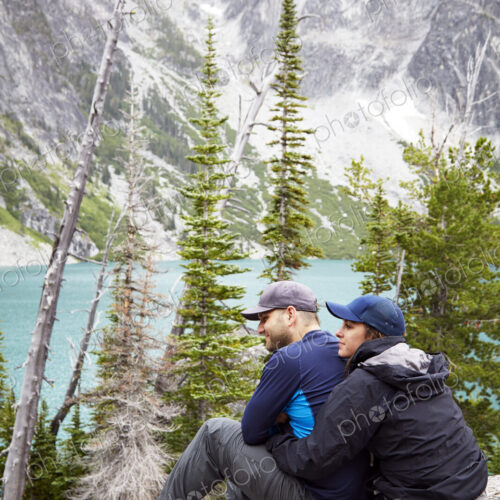 Couple admiring mountains and remote lake Couple admiring mountains and remote lake