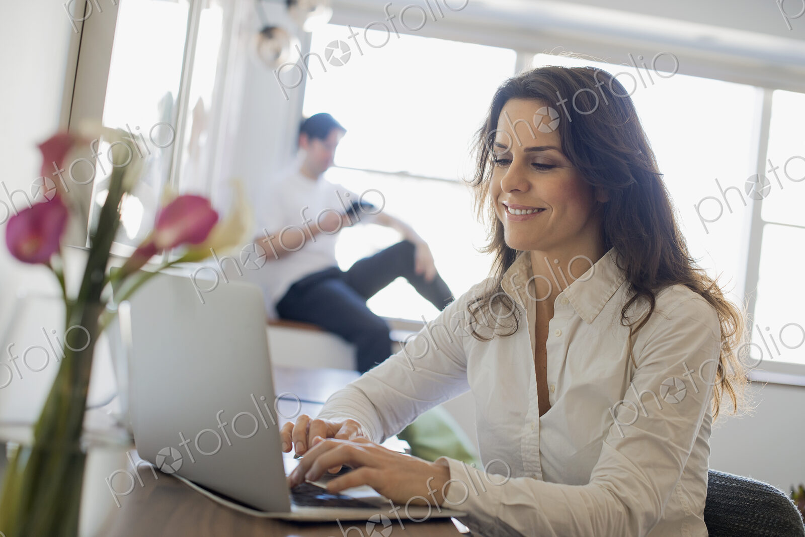 Couple at Home, Woman using Laptop and Man using Tablet