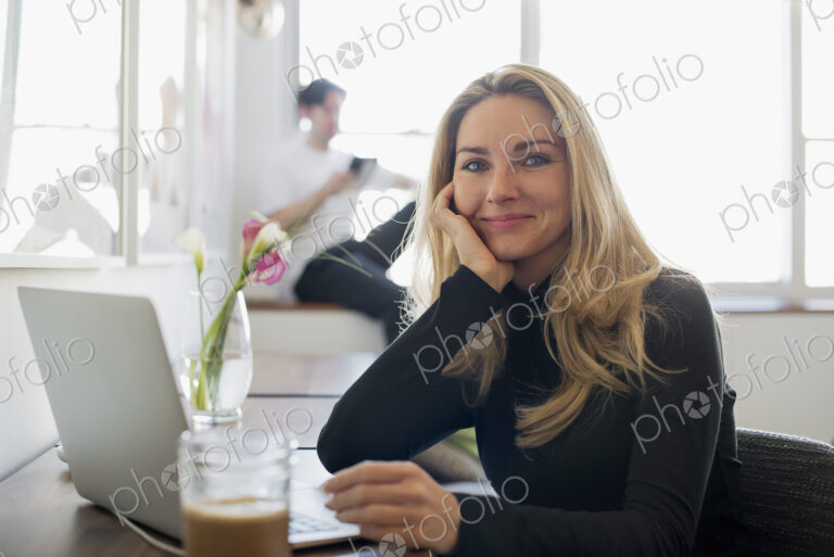 Couple at Home, Woman using Laptop and Man using Tablet