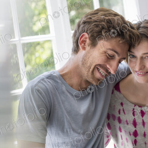 Couple embracing by a window. Couple embracing by a window.