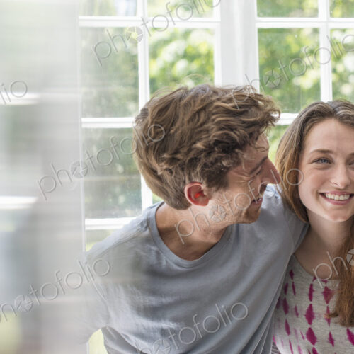 Couple embracing by a window. Couple embracing by a window.