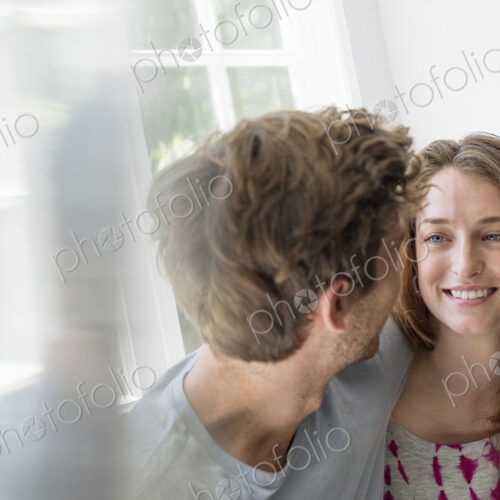 Couple embracing by a window. Couple embracing by a window.