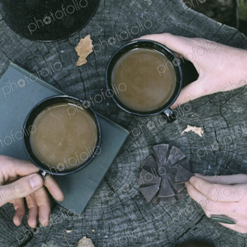 Couple having coffee in a forest, two mugs of coffee, a coffee pot and a pair of… Couple having coffee in a forest, two mugs of coffee, a coffee pot and a pair of…