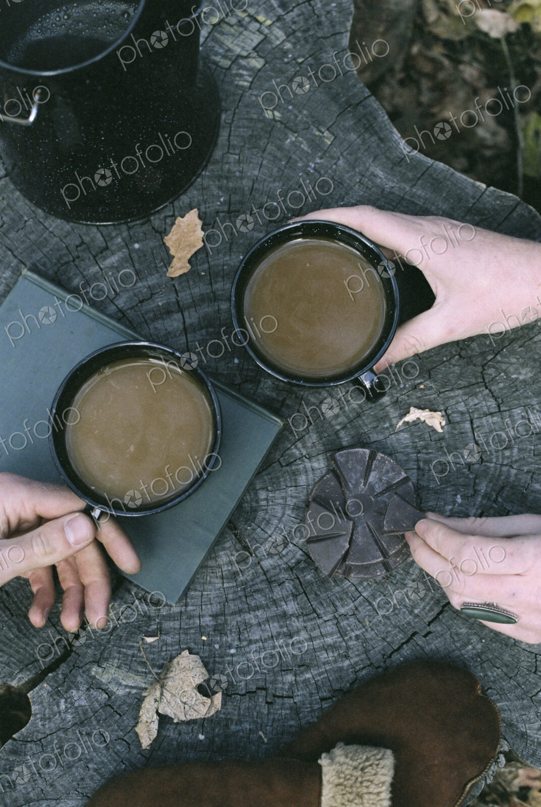 Couple having coffee in a forest, two mugs of coffee, a coffee pot and a pair of…